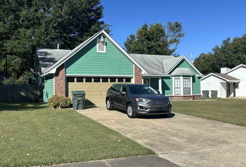 View of front of house with a front yard and a garage