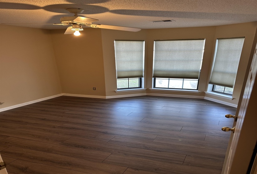 Unfurnished room with ceiling fan, dark hardwood / wood-style flooring, and a textured ceiling