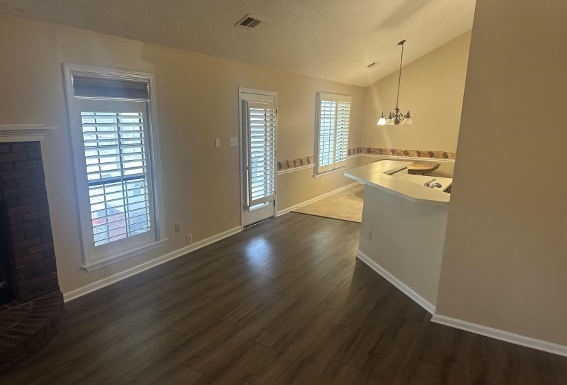 Unfurnished dining area featuring lofted ceiling, a chandelier, and dark wood finished floors