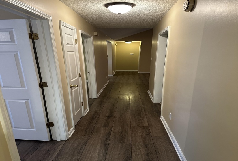 Hall with dark hardwood / wood-style floors and a textured ceiling