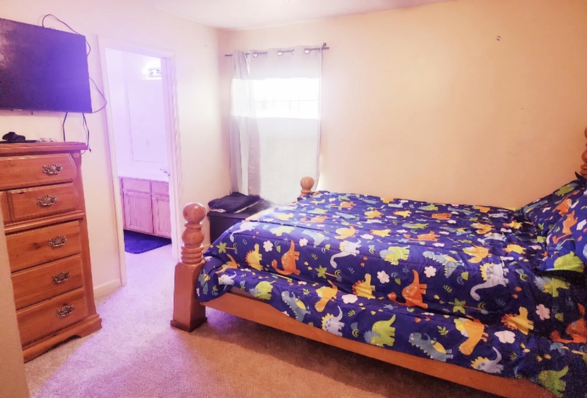 Bedroom with light colored carpet and ensuite bath