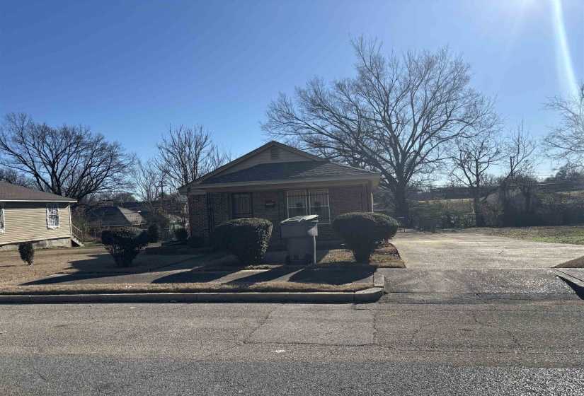 View of front of house featuring covered porch, driveway, and brick siding