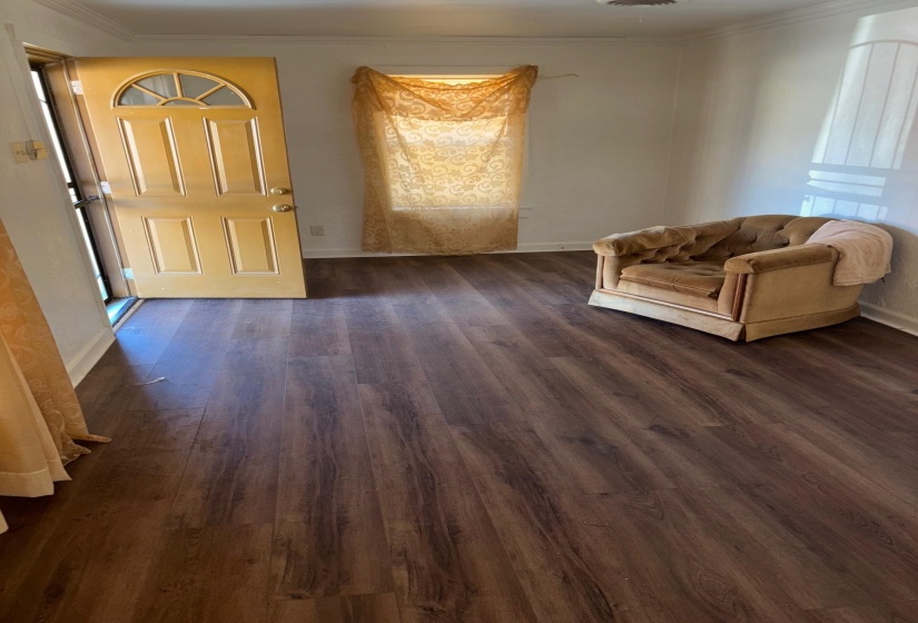 Entrance foyer with ornamental molding and dark wood-style flooring