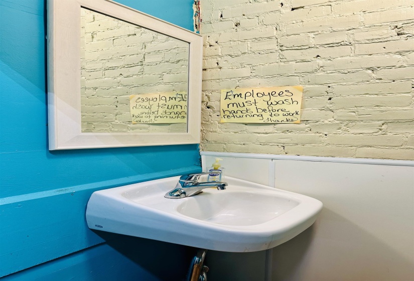 Bathroom with a sink and brick wall