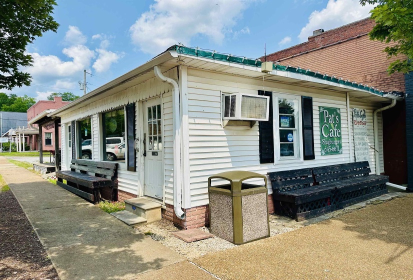 View of side of property featuring a wall unit AC and entry steps