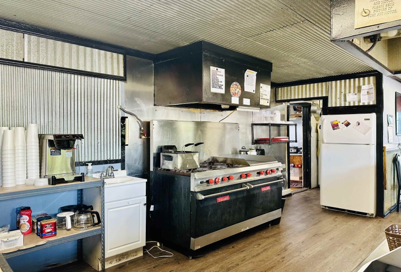 Kitchen featuring freestanding refrigerator, premium range, a sink, and wood finished floors