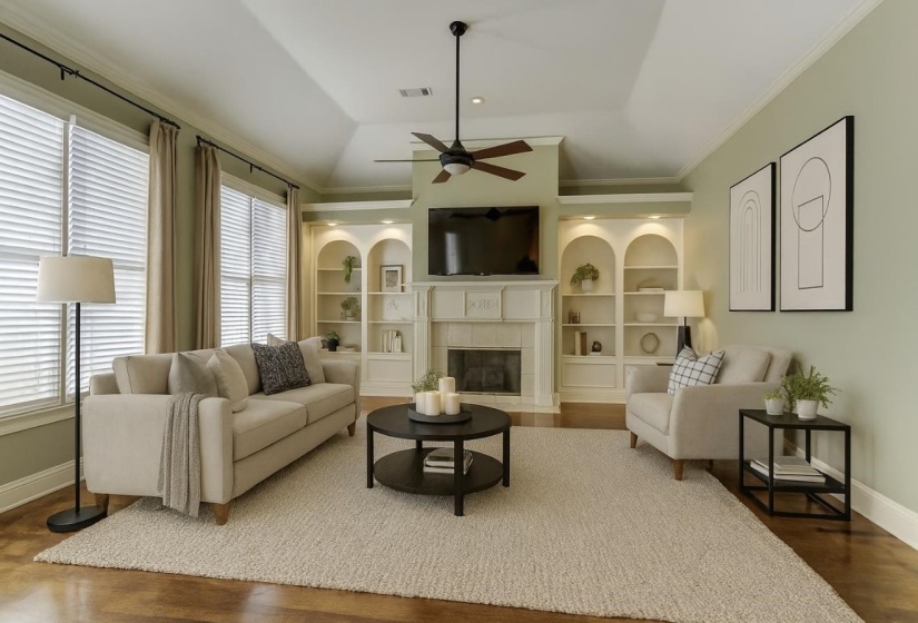 Living room with vaulted ceiling, dark wood-style floors, a tile fireplace, ornamental molding, and ceiling fan
