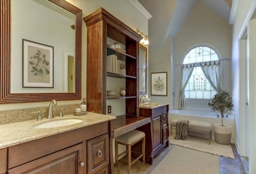 Full bath with double vanity, a garden tub, and crown molding