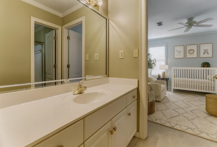 Ensuite bathroom with ornamental molding, vanity, and ceiling fan