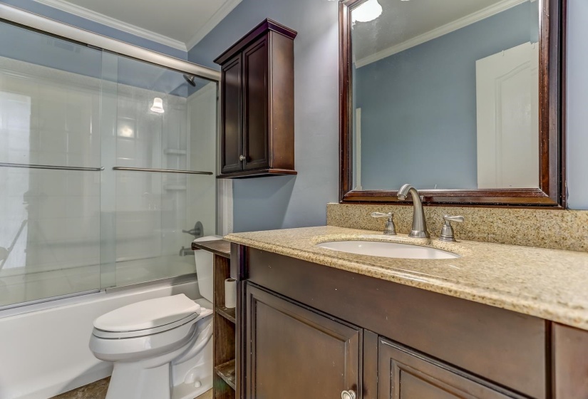 Full bathroom with toilet, combined bath / shower with glass door, ornamental molding, and vanity