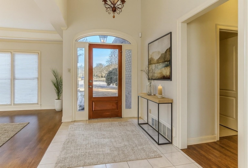 Tiled entryway featuring a high ceiling and a chandelier