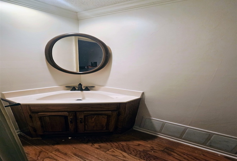 Bathroom with vanity, ornamental molding, a textured ceiling, and dark wood finished floors
