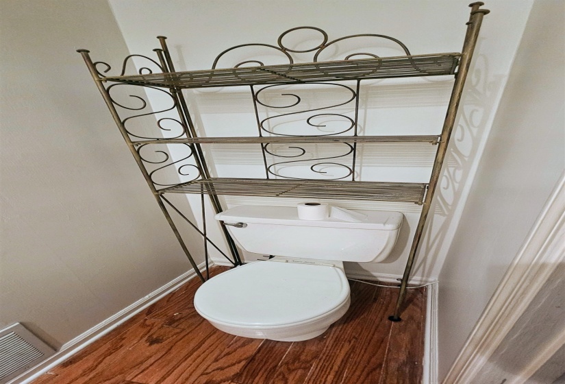 Bathroom with dark wood finished floors and toilet