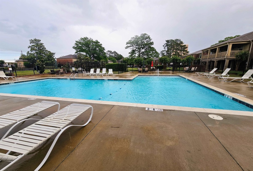 Community pool with fence and a patio area