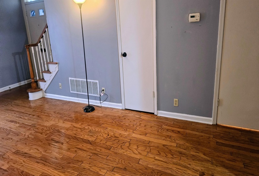 Unfurnished living room with stairway and wood finished floors