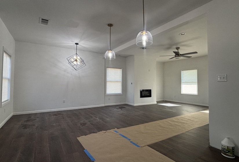 Unfurnished living room with ceiling fan and dark hardwood / wood-style floors