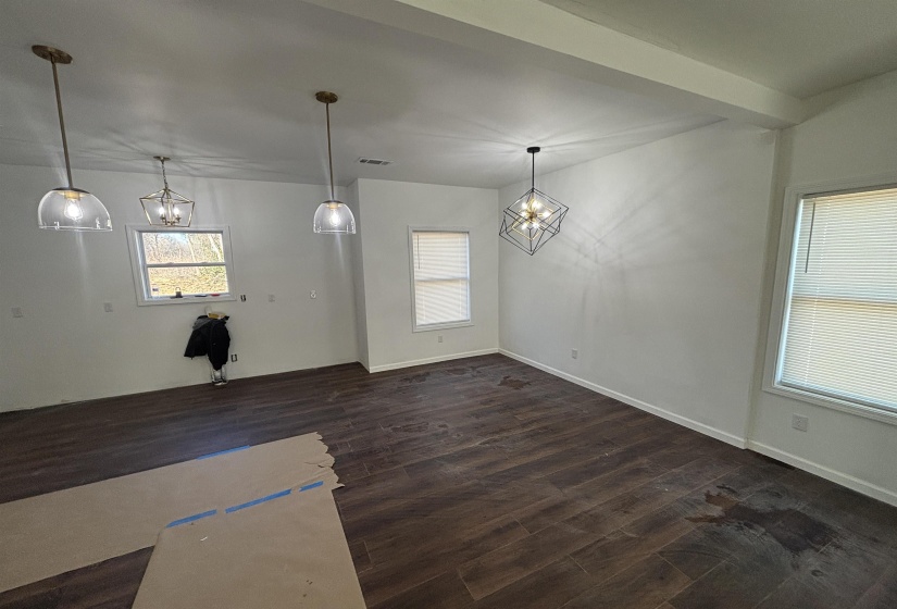 Unfurnished dining area featuring dark hardwood / wood-style flooring and an inviting chandelier