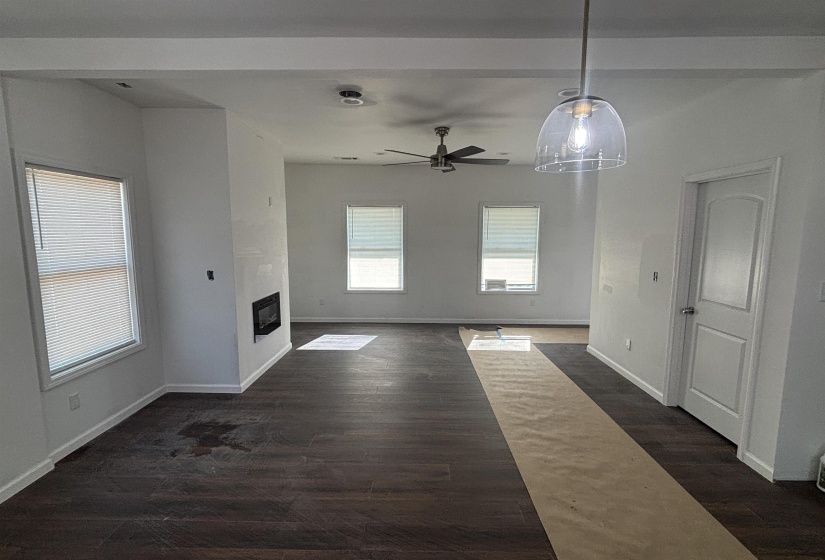 Unfurnished living room featuring dark hardwood / wood-style floors and ceiling fan