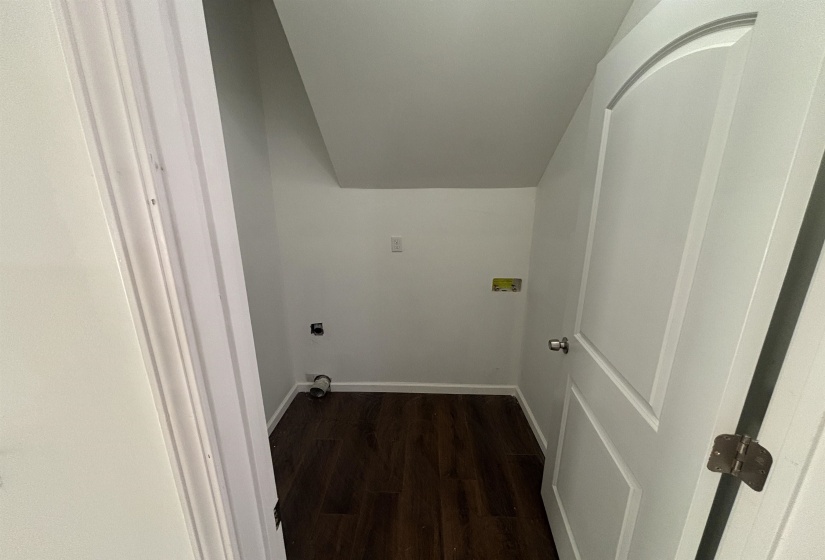 Clothes washing area with electric dryer hookup and dark hardwood / wood-style flooring