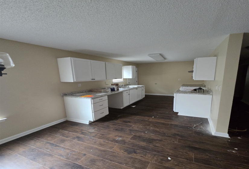 Kitchen featuring dark hardwood / wood-style flooring, sink, a textured ceiling, and white cabinets