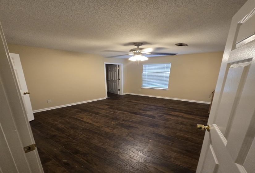 Unfurnished room with a textured ceiling, dark wood-type flooring, and ceiling fan