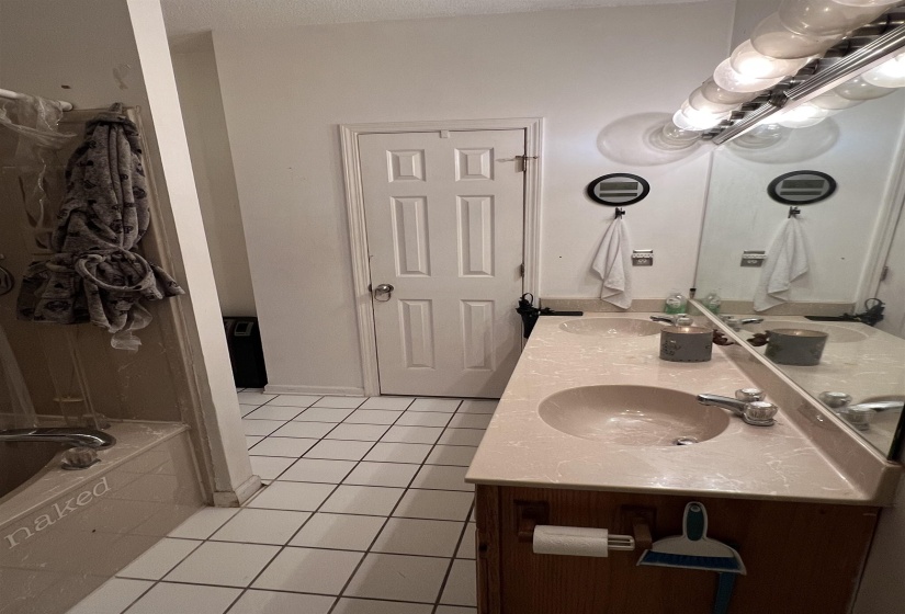 Bathroom with double vanity and light tile patterned flooring