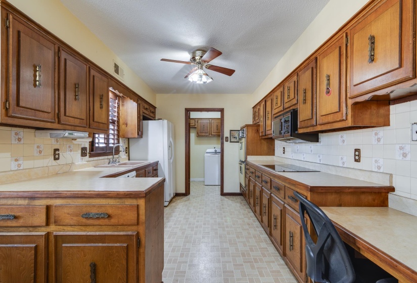 Kitchen with decorative backsplash, brown cabinetry, light countertops, and a textured ceiling