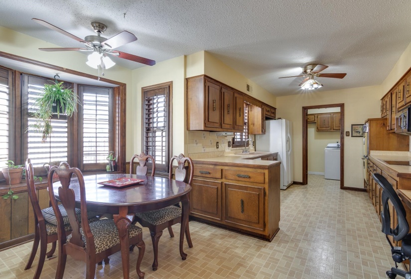 Kitchen featuring ceiling fan, plenty of natural light, brick patterned floors, and a textured ceiling