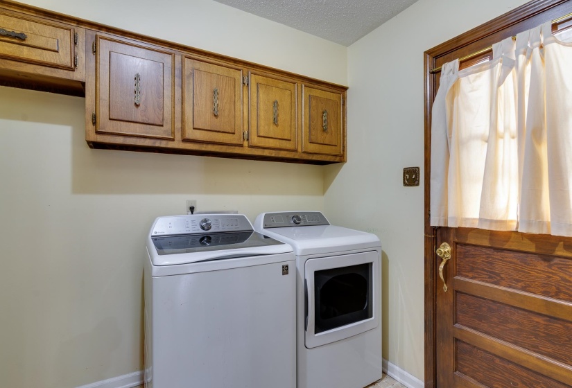 Laundry room featuring a textured ceiling, cabinet space, and separate washer and dryer