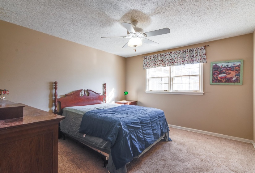 Bedroom featuring carpet flooring, a textured ceiling, and a ceiling fan