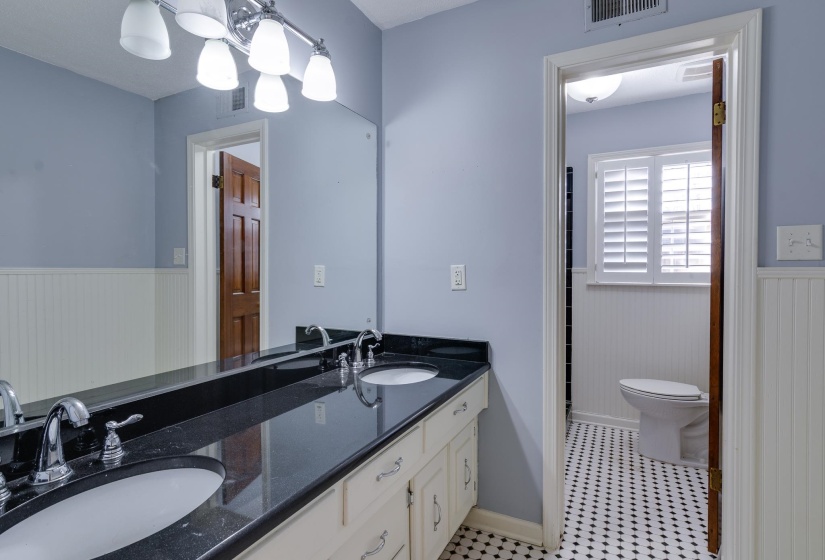 Bathroom with a wainscoted wall and double vanity