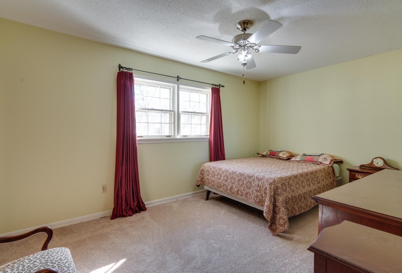 Bedroom with carpet, a textured ceiling, and a ceiling fan