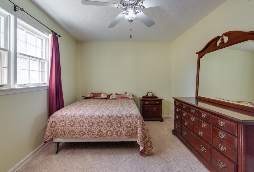 Bedroom featuring light carpet, ceiling fan, and a textured ceiling