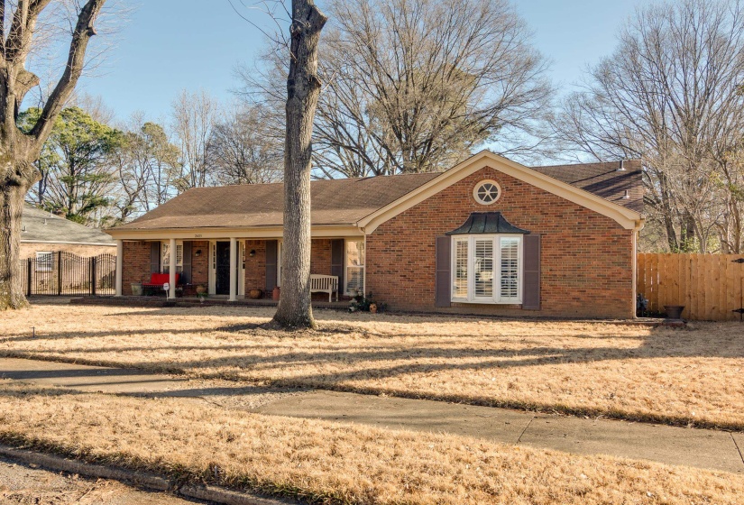Ranch-style house with a porch, brick siding, a shingled roof, and a gate