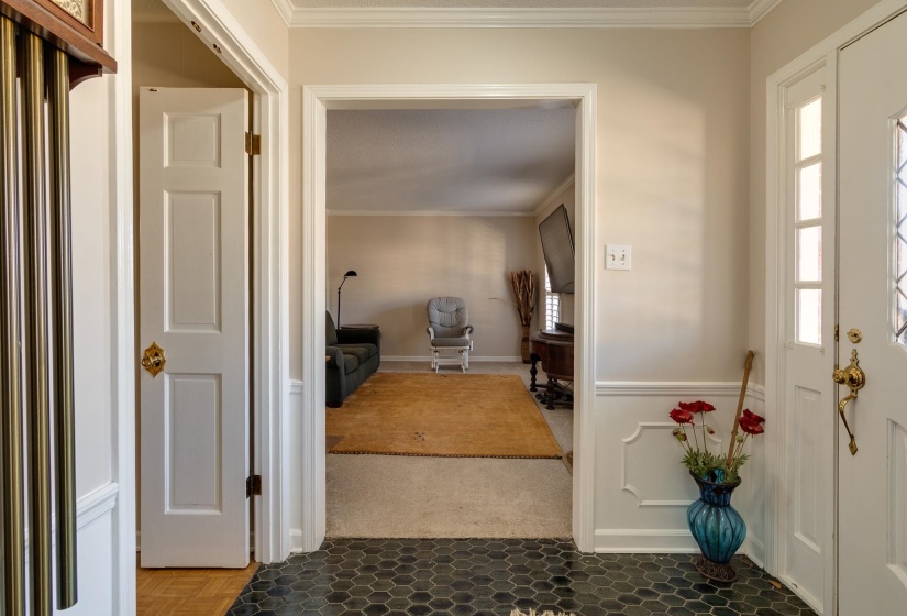 Carpeted foyer entrance featuring ornamental molding