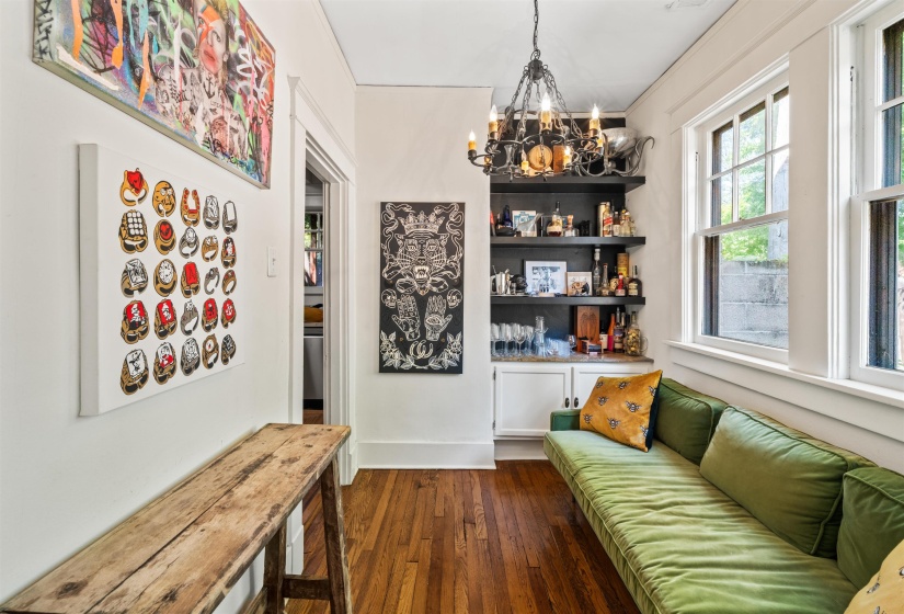 Sitting room with dark wood-style flooring, a chandelier, and crown molding