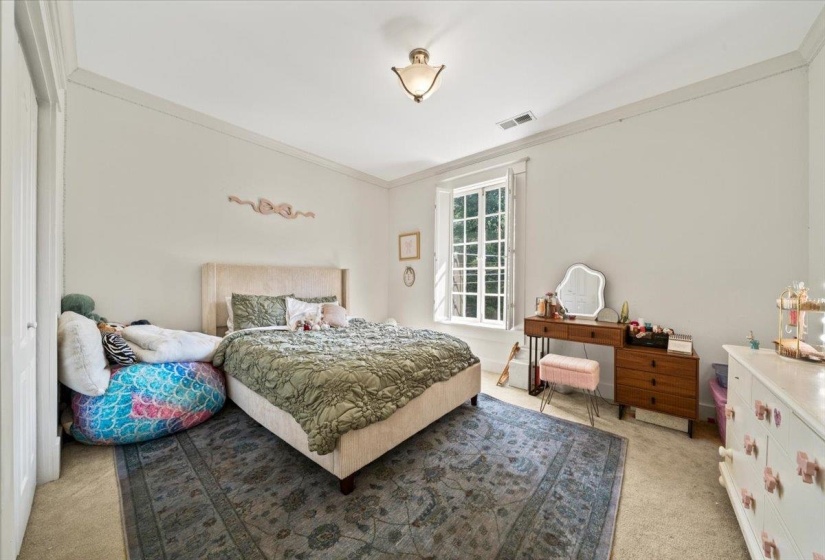 Bedroom featuring light colored carpet and crown molding