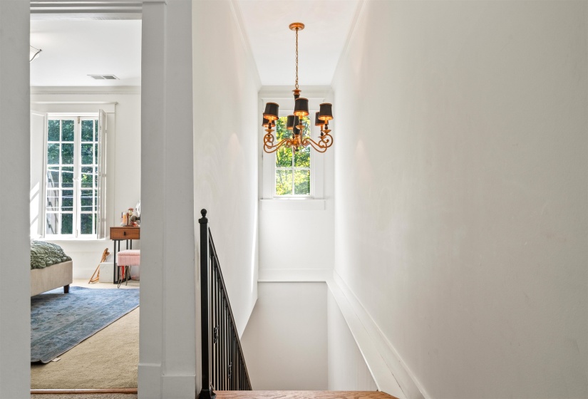 Stairs with carpet flooring and a chandelier