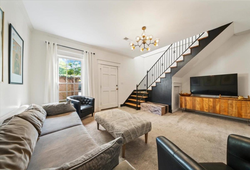 Living area with stairway, carpet flooring, a chandelier, and ornamental molding