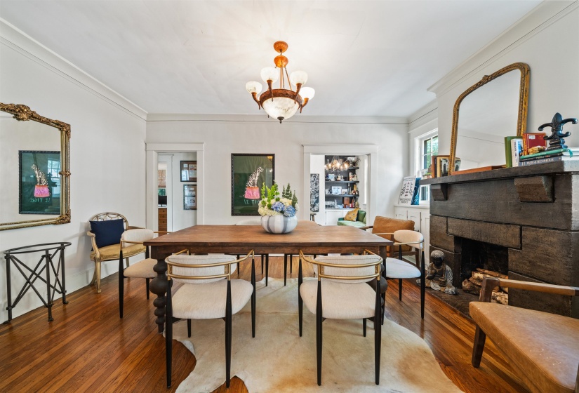 Dining room featuring hardwood / wood-style flooring, a fireplace, a chandelier, and ornamental molding