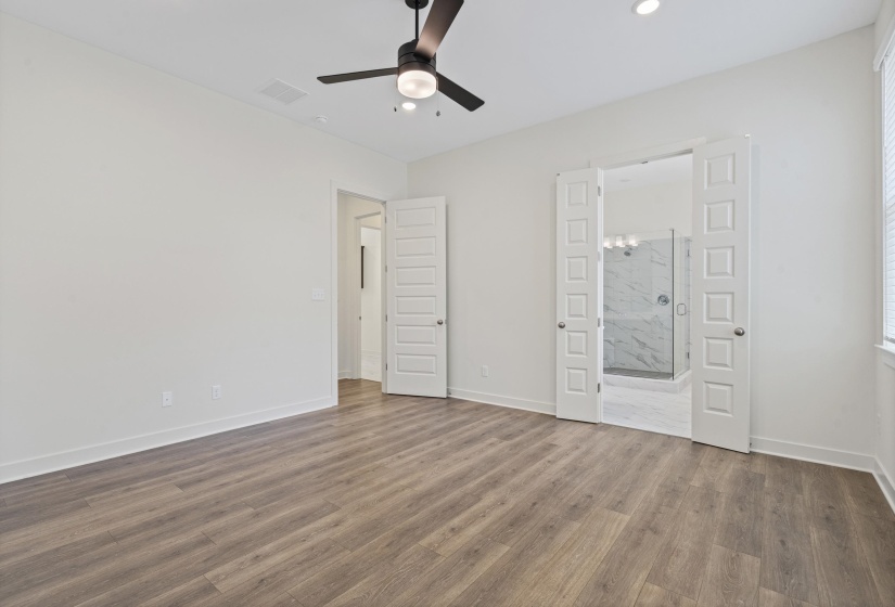 Spacious room featuring wood-finish flooring, recessed lighting, and a contemporary ceiling fan