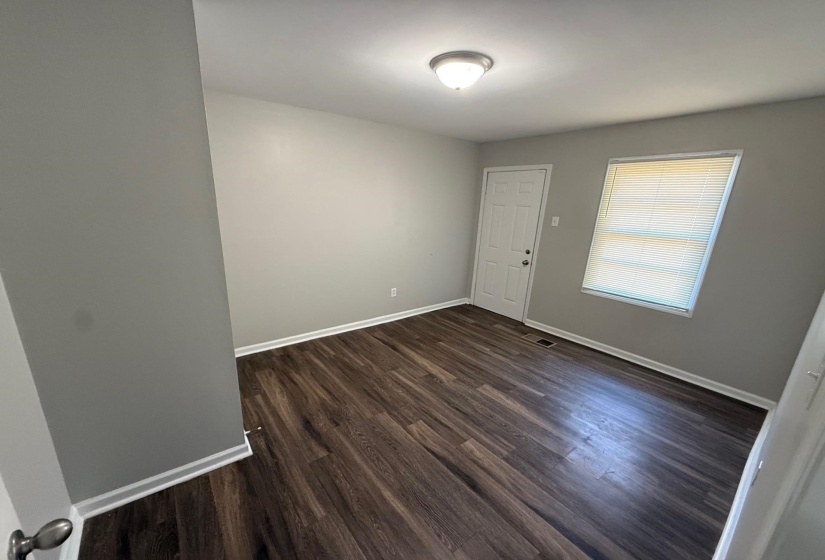 Unfurnished room with dark wood finished floors and baseboards