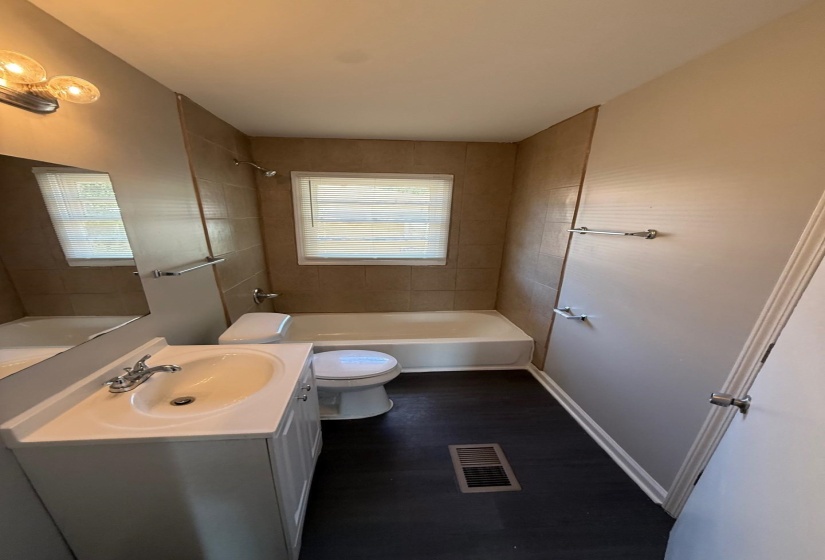 Full bath featuring vanity, shower / washtub combination, and dark wood-style flooring