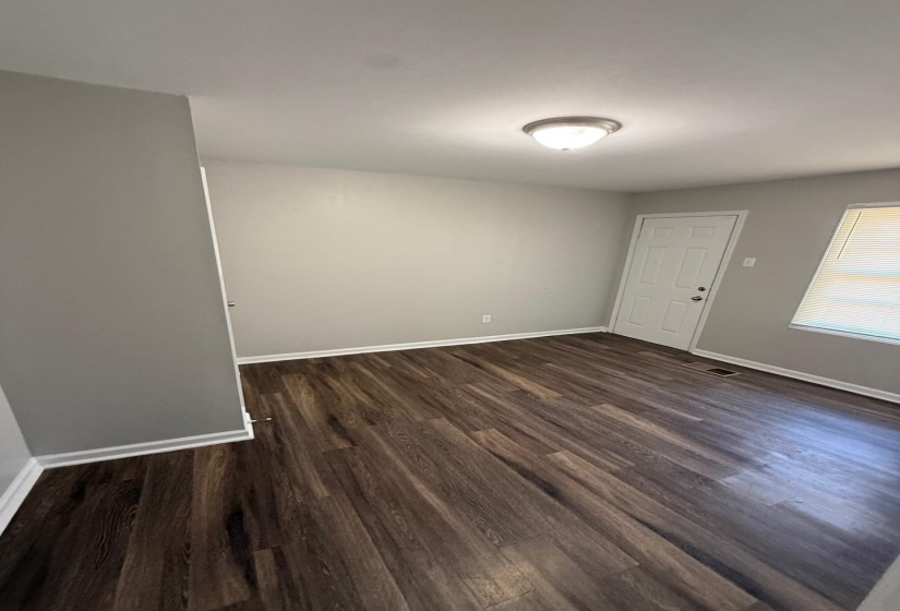 Spare room with baseboards and dark wood-style floors