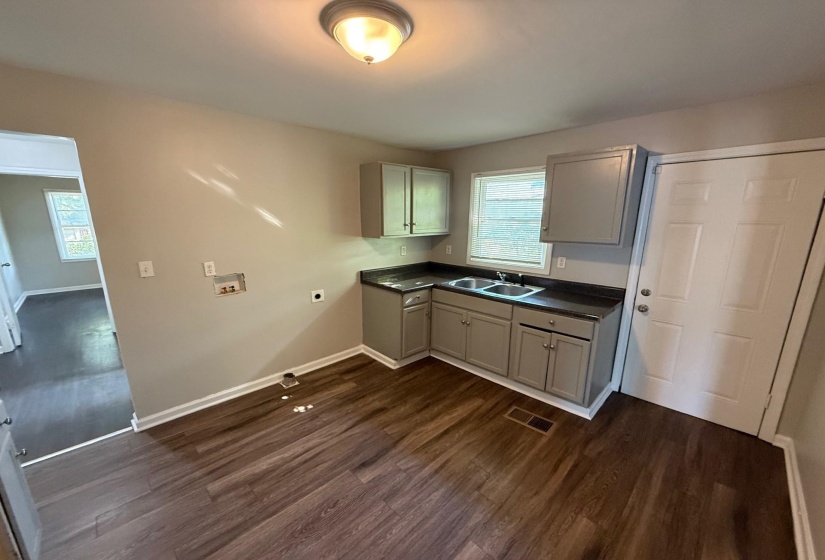 Washroom featuring dark wood finished floors, washer hookup, cabinet space, and electric dryer hookup