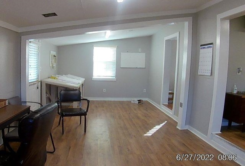 Sitting room with wood finished floors, lofted ceiling, and crown molding