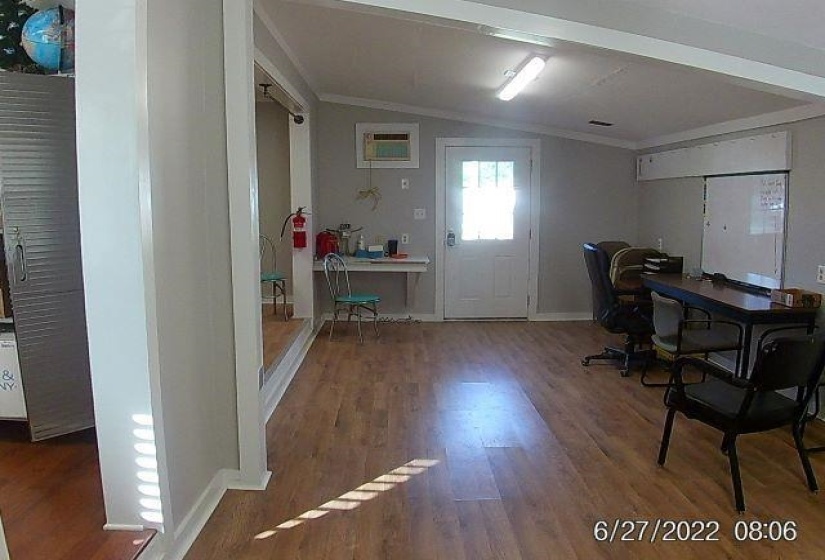 Office with wood finished floors, lofted ceiling, and crown molding
