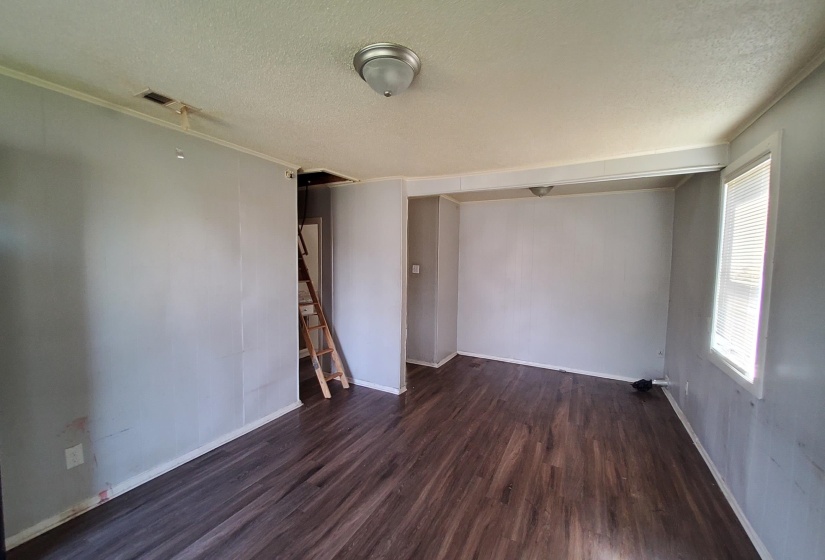 Spare room with a textured ceiling, dark wood finished floors, and stairway