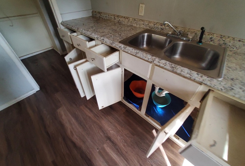 Kitchen with light countertops, white cabinetry, and dark wood-style flooring