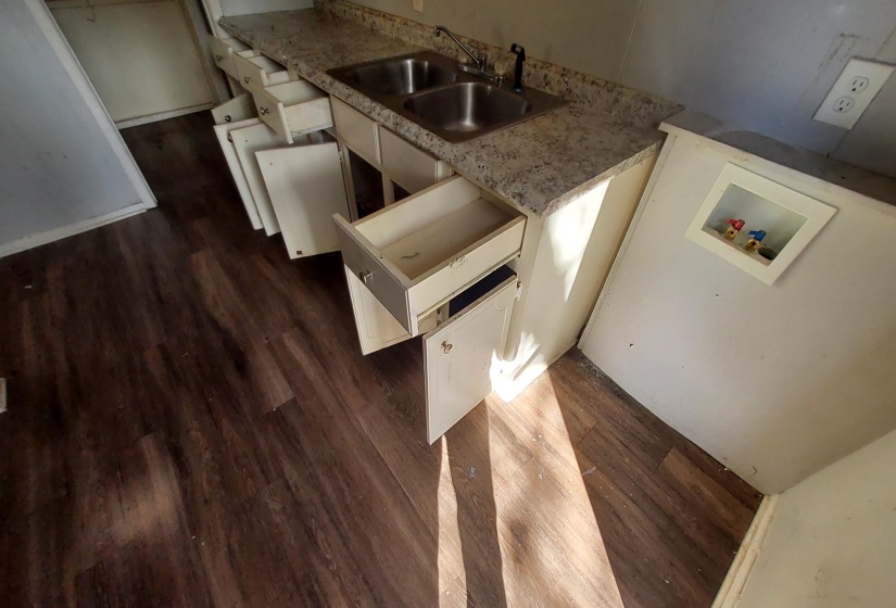 Kitchen featuring light countertops, dark wood-style floors, and white cabinets